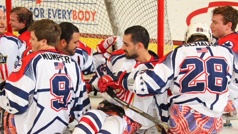 Group of sledge hockey players celebrating on the ice