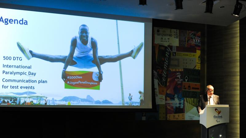 Man on podium, speaking to an audience