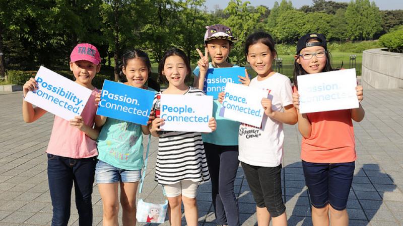 Group of kids showing signs with the words 'Passion. Connected'.