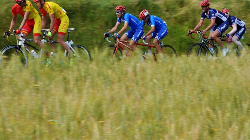 Three tandems with six cyclists surrounded by nature