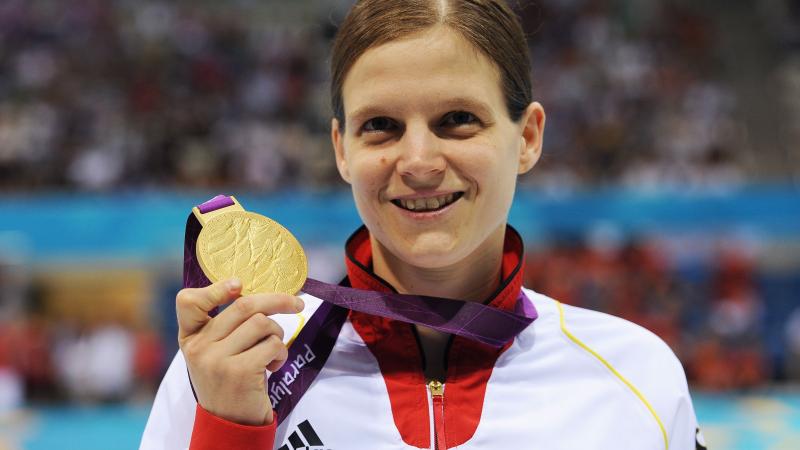 Portrait shot of woman showing a medal and smiling