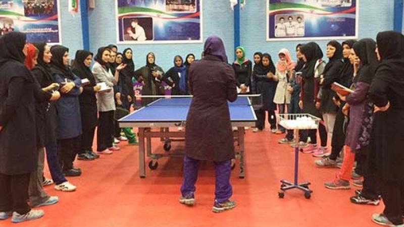 Group of women grouped around a table tennis table