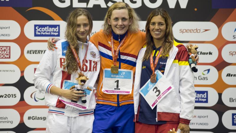 Three swimmers pose with their medals