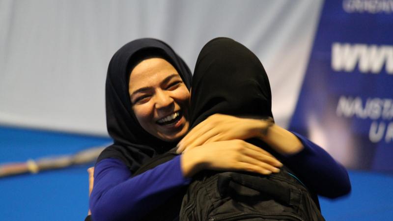 Two smiling women hugging