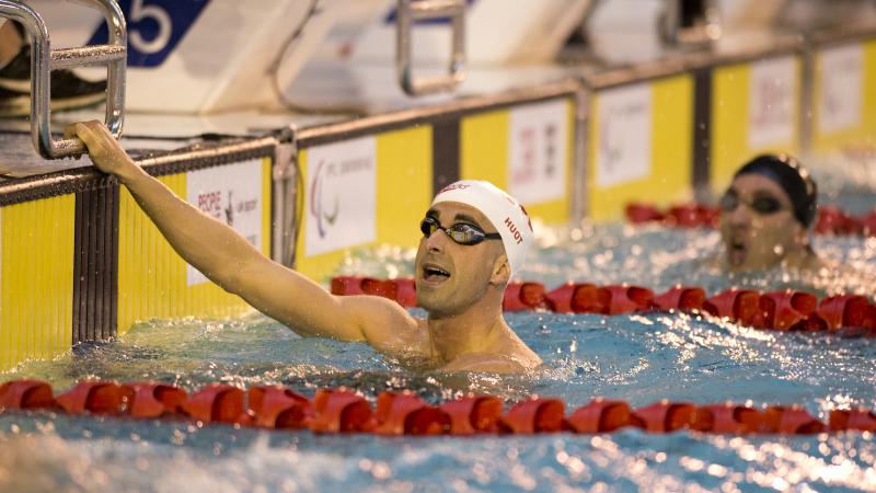 Two men in a swimming pool, after a race