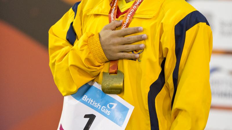 Carlos Serrano Zarate - 2015 IPC Swimming World Championships Glasgow Man in yellow training suit on a podium.