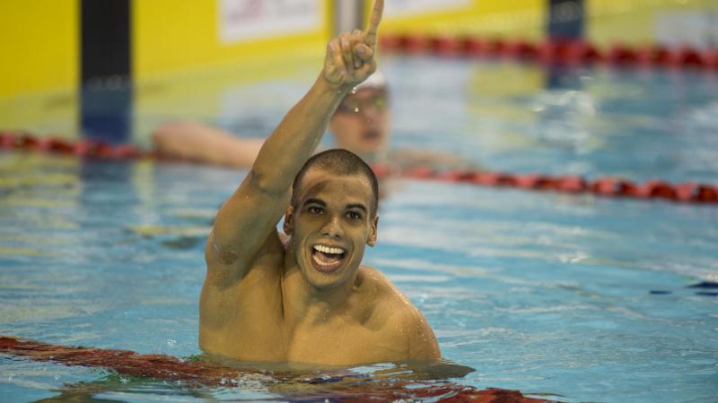 Man in water, holding one arm in the air, celebrating