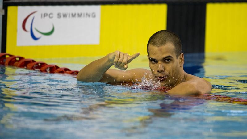 A swimmer stays in the water after finishing a race.