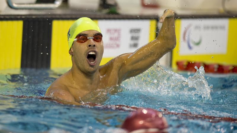 Man in the water, waving one arm in the air, celebrating