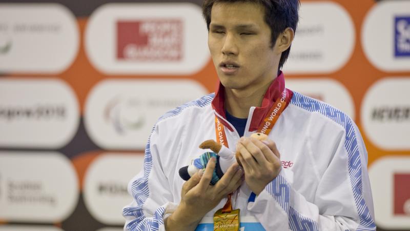 Man with a medal around his neck on a podium