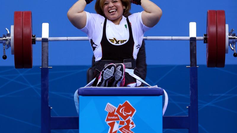 A picture of a powerlifter on a bench celebrating