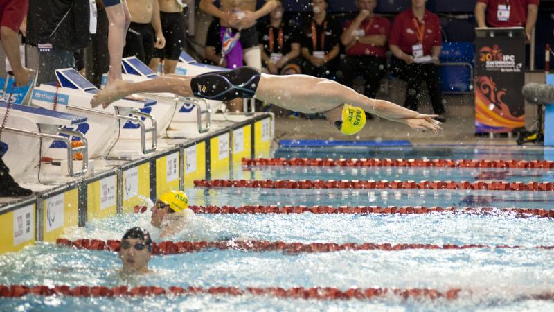 View on the starting zone in a swimming pool, one athlete jumping in the water