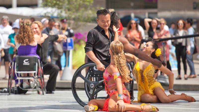 Group of dancers (wheelchairs and standing) on a stage performing