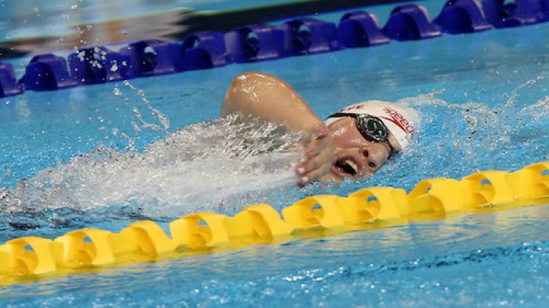 Tess Routliffe swimming in the pool. Her head is just above water and facing the camera.