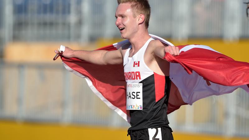 Mitchell Chase walks wrapped in the Canadian flag