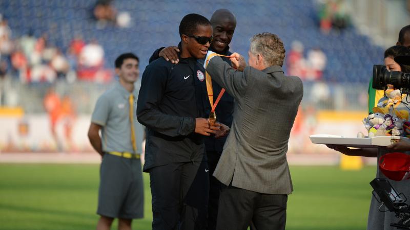 Two men on the podium receiving a medal