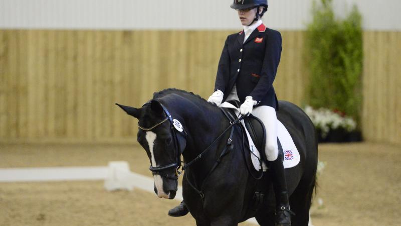 Woman riding a black horse