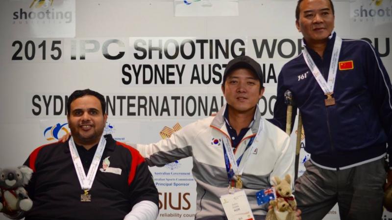 Three men on a podium with medals