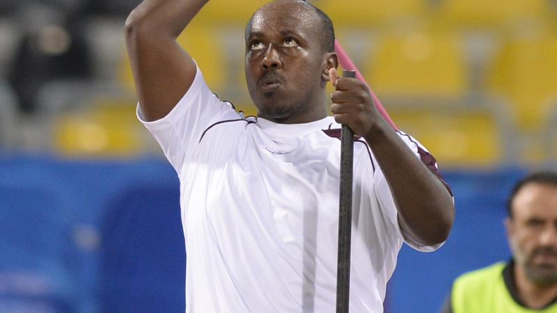 Man sitting, throwing a javelin