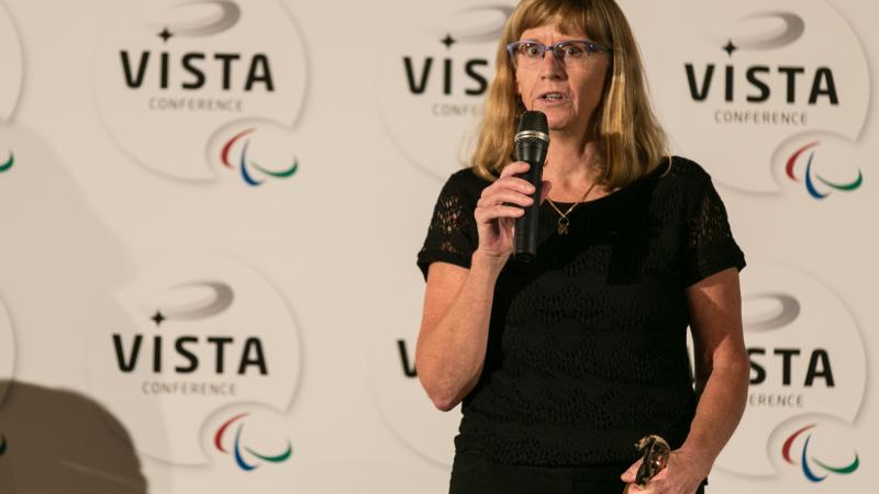 Woman on a stage, giving a speech