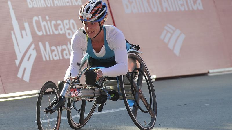 Woman in racing wheelchair, smiling