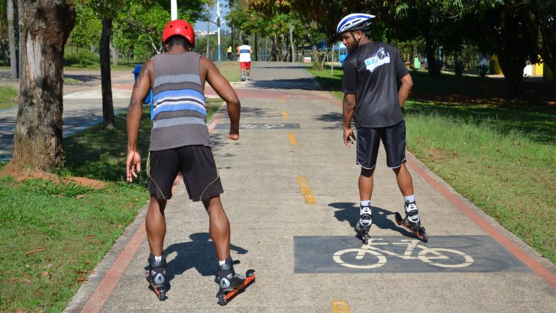 Two men on rollerblades on a bicycle way