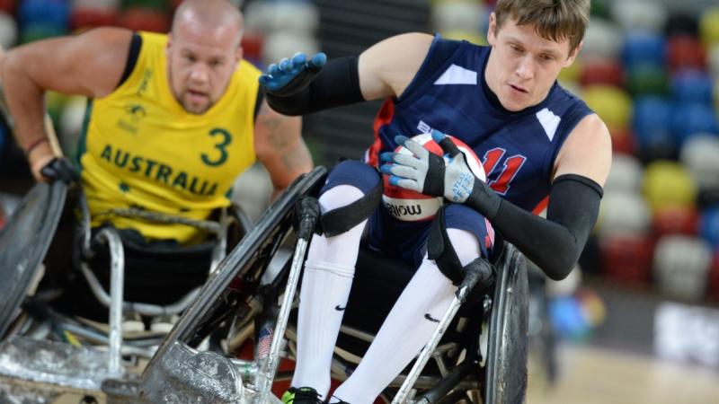 Two wheelchair rugby players fighting for the ball