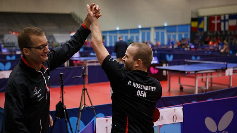 Two table tennis players celebrate.