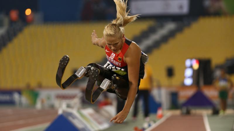 Double leg amputee woman doing long jump