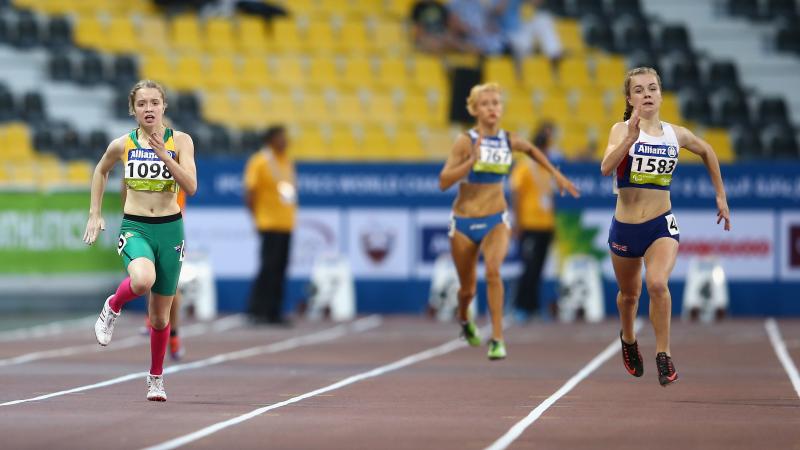 Two young women running on a track, head to head