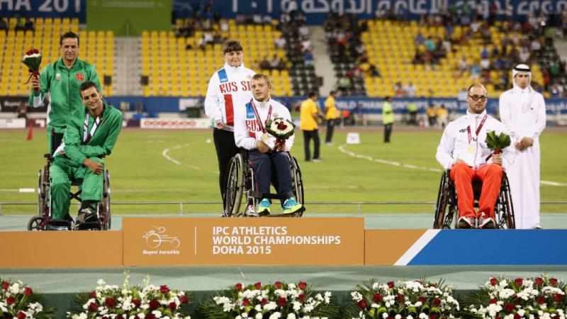 Podium with three men in training suits