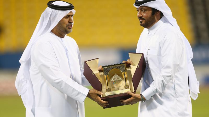 Mr Ameer Al Mulla (R) presents a gift to Mr Mohammed Alhameli at the closing ceremony of the IPC Athletics World Championships at Suhaim Bin Hamad Stadium in DOha, Qatar.