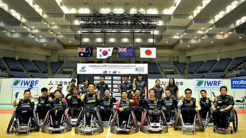 A team of wheelchair rugby players pose for a photo.