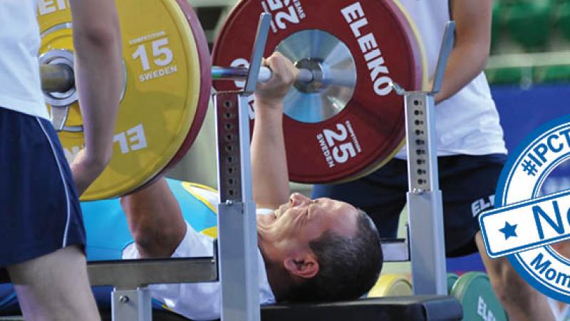 Powerlifter on a bench, raising a bar