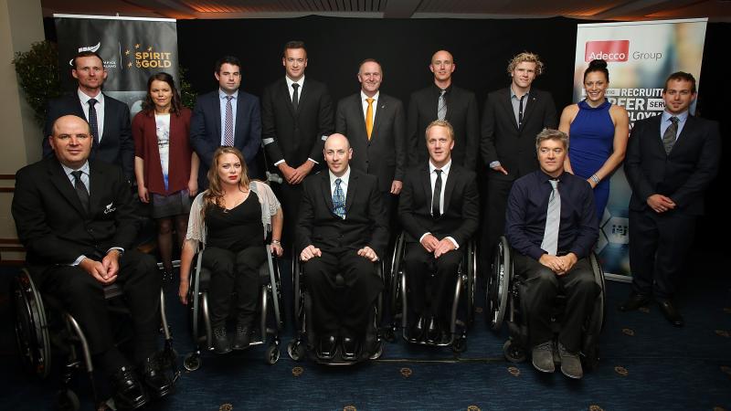 Group picture of people dressed smart, standing and in wheelchairs