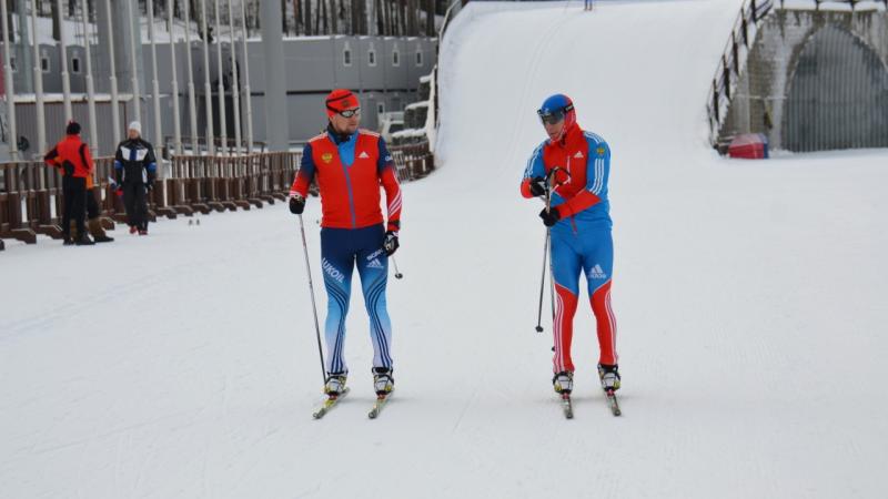 Two cross-country skier in blue competition clothes on the slopes