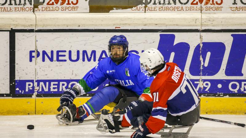 Two ice sledge hockey players in action