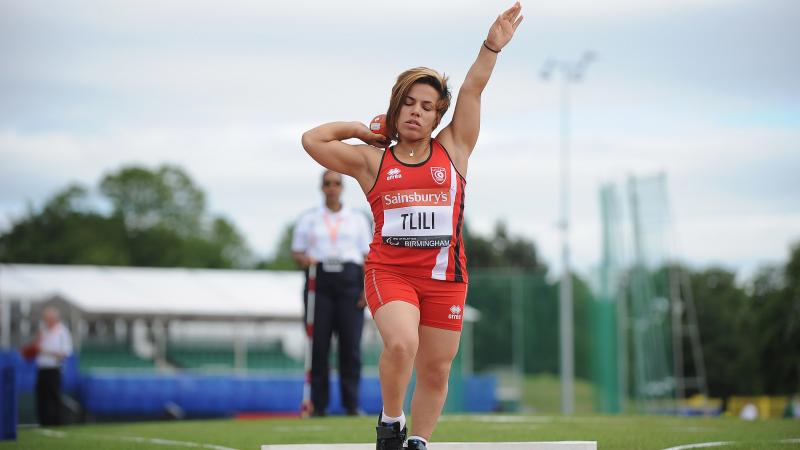 a female from Tunisia wearing red and competing in the shot put