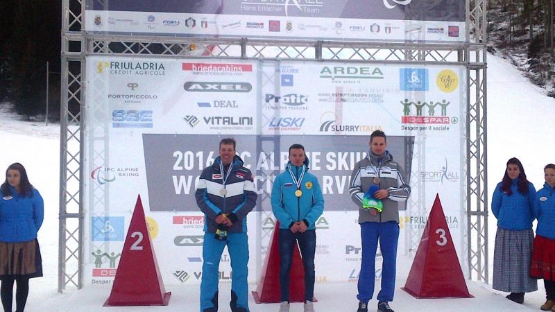 Podium with three men smiling.