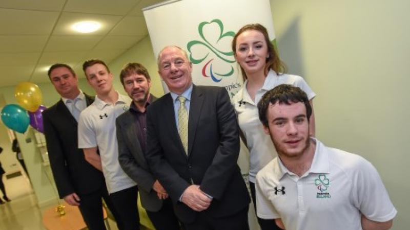 Six people pose in front of Paralympics Ireland banner