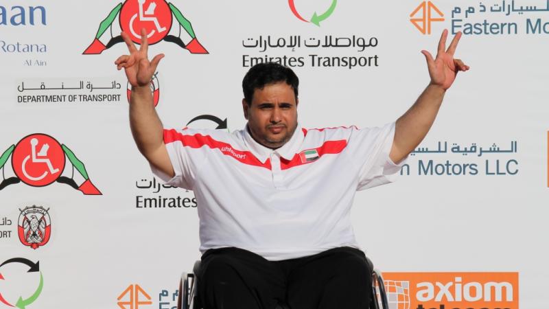 Man in wheelchair on a podium, celebrating