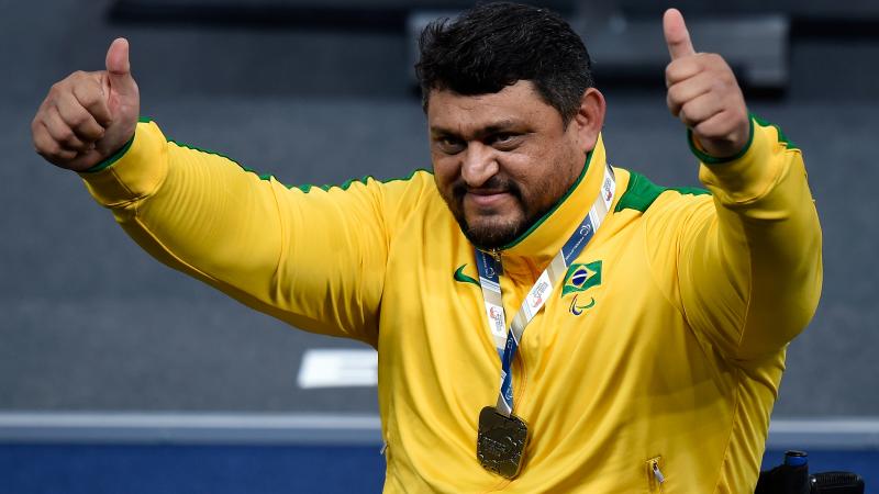 Man in yellow training suit raising his arms