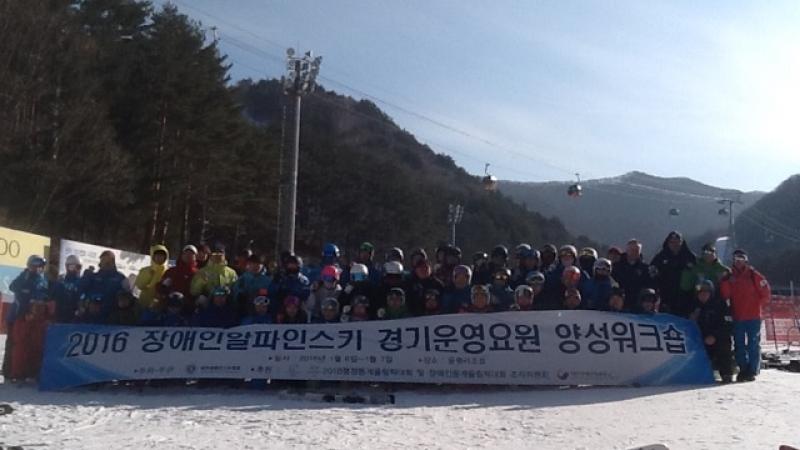 Group shot of people in the snow holding a banner