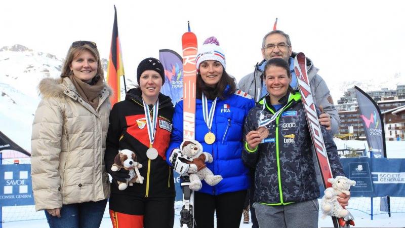 Three women alpine skiers pose with their medals from a World Cup