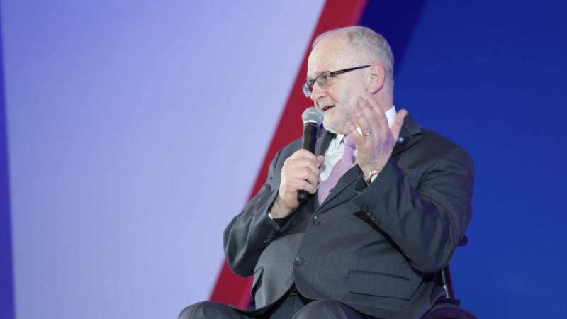 Man in wheelchair speaking on a stage