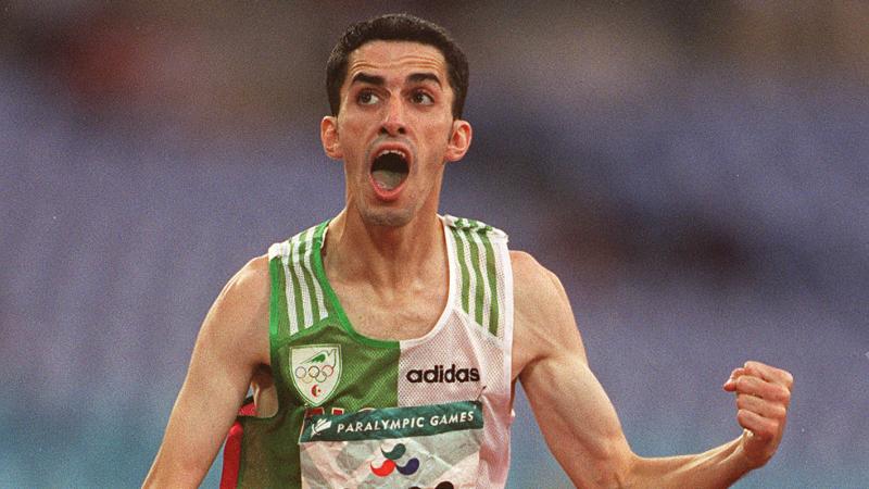 Man in running clothes, crossing a finish line, celebrating