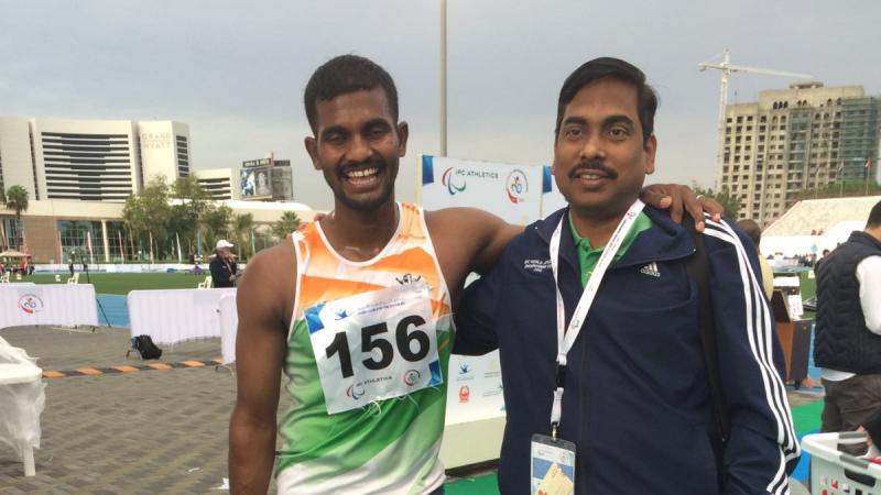 Man with a running blade posing for the camera with another man