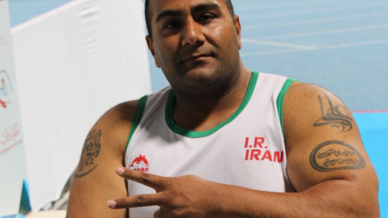 Iran's Hamed Amiri shows the "V" for victory sign with his fingers