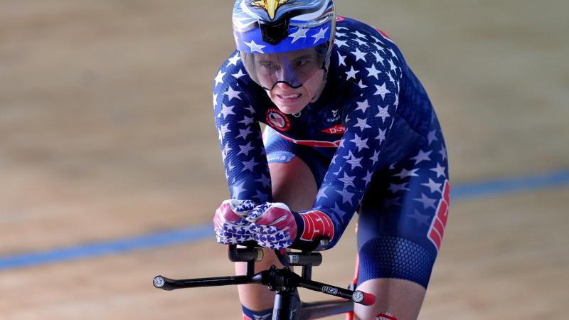 Male cyclists pedals on track velodrome.