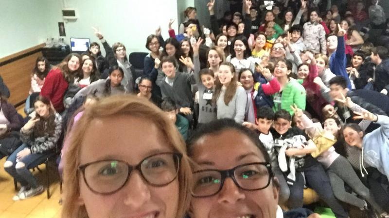 Selfie of two women smiling with many kids in the background